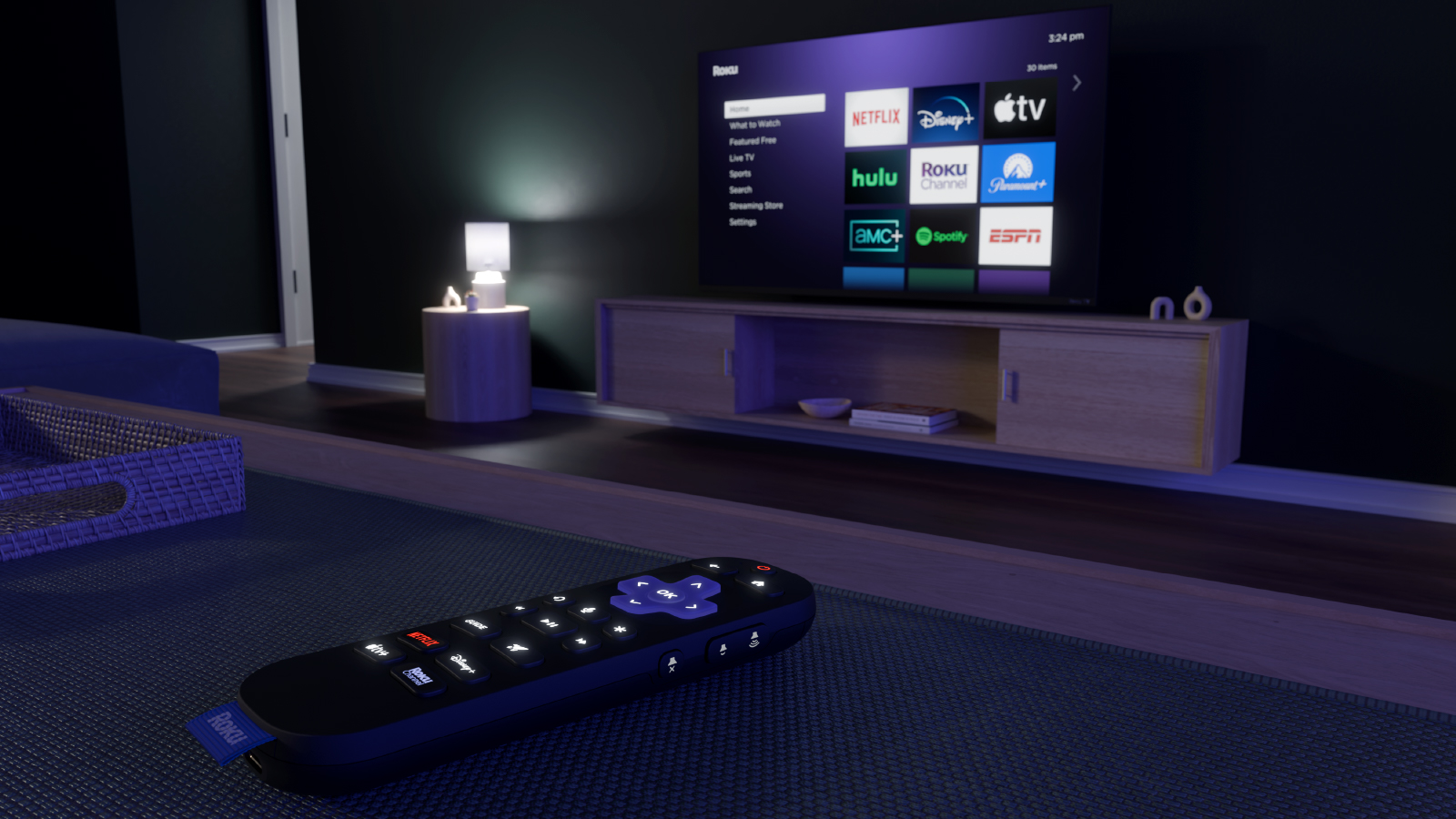 Close-up view of a Roku remote control on a table with a television screen in the background showing streaming apps including Netflix, Disney+, Apple TV, Hulu, Roku Channel, Paramount+, ESPN, AMC+, and Spotify.