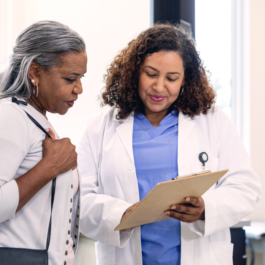 Two women in white coats engaged in conversation, showcasing a professional and collaborative atmosphere.