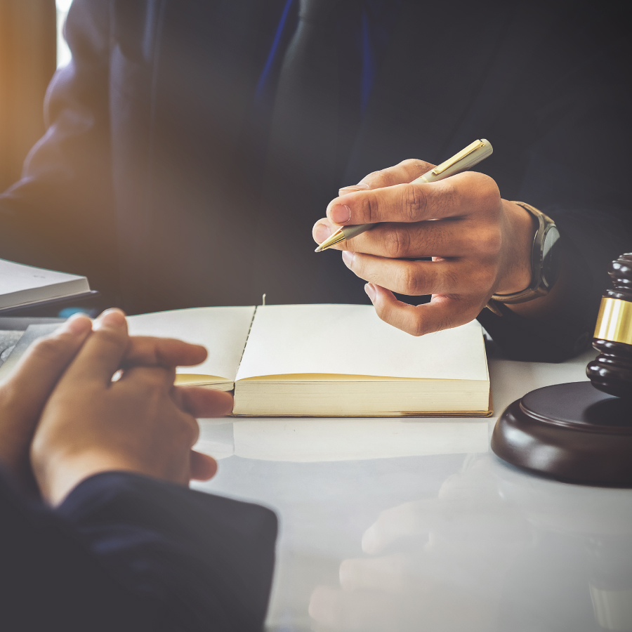 A lawyer and client seated at a desk, discussing legal matters in a formal office environment.