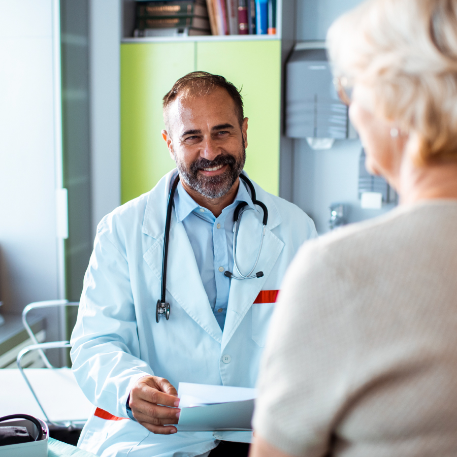 A man wearing a white coat stands confidently, showcasing professionalism and expertise in his field.