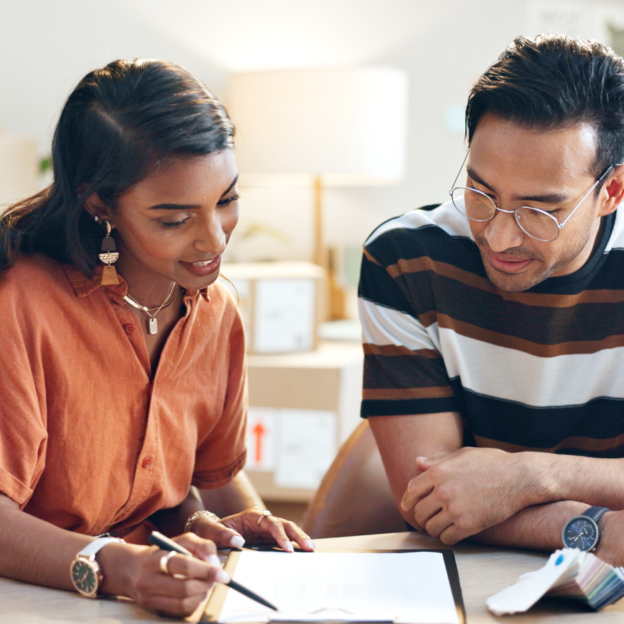 A man and woman engaged in a professional discussion while examining a contract together at a workspace.