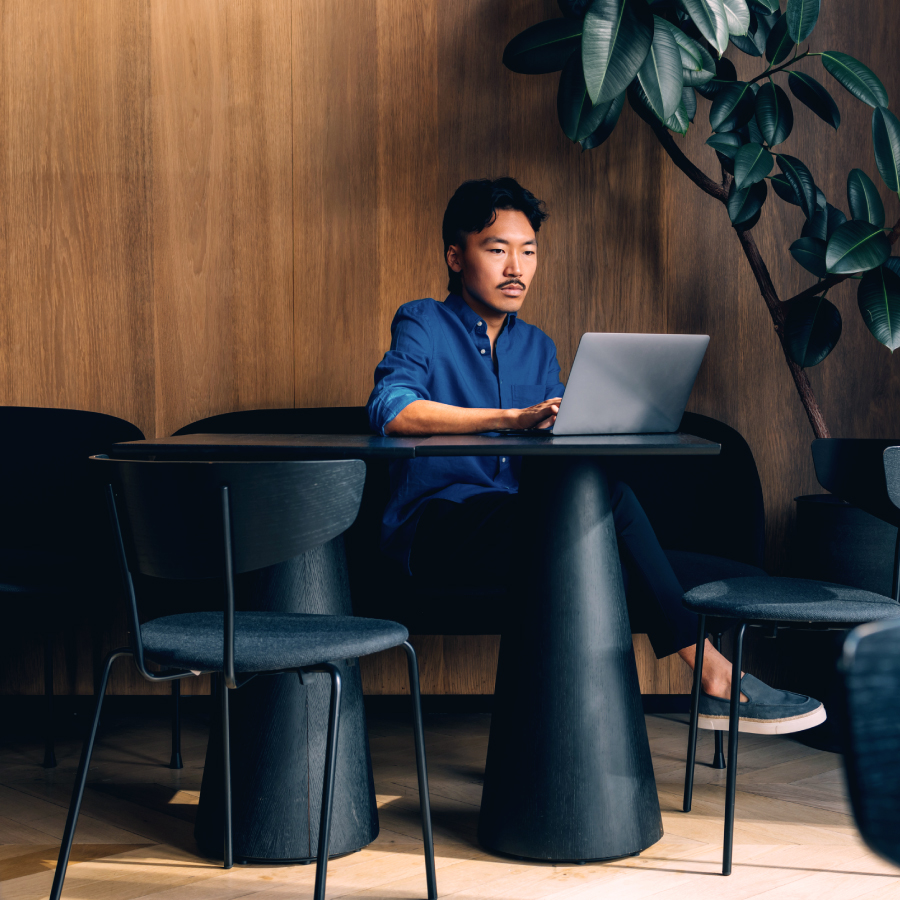 A man at a table using a laptop, concentrating on his tasks or research.