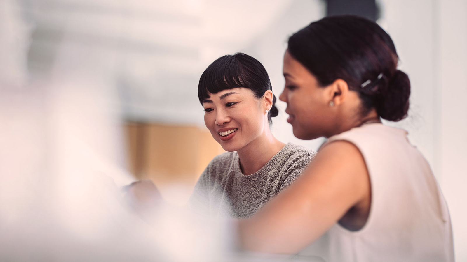 Two professionals engaged in a discussion, representing collaboration in a connected supply chain environment. The background is softly blurred, emphasizing teamwork and digital transformation.