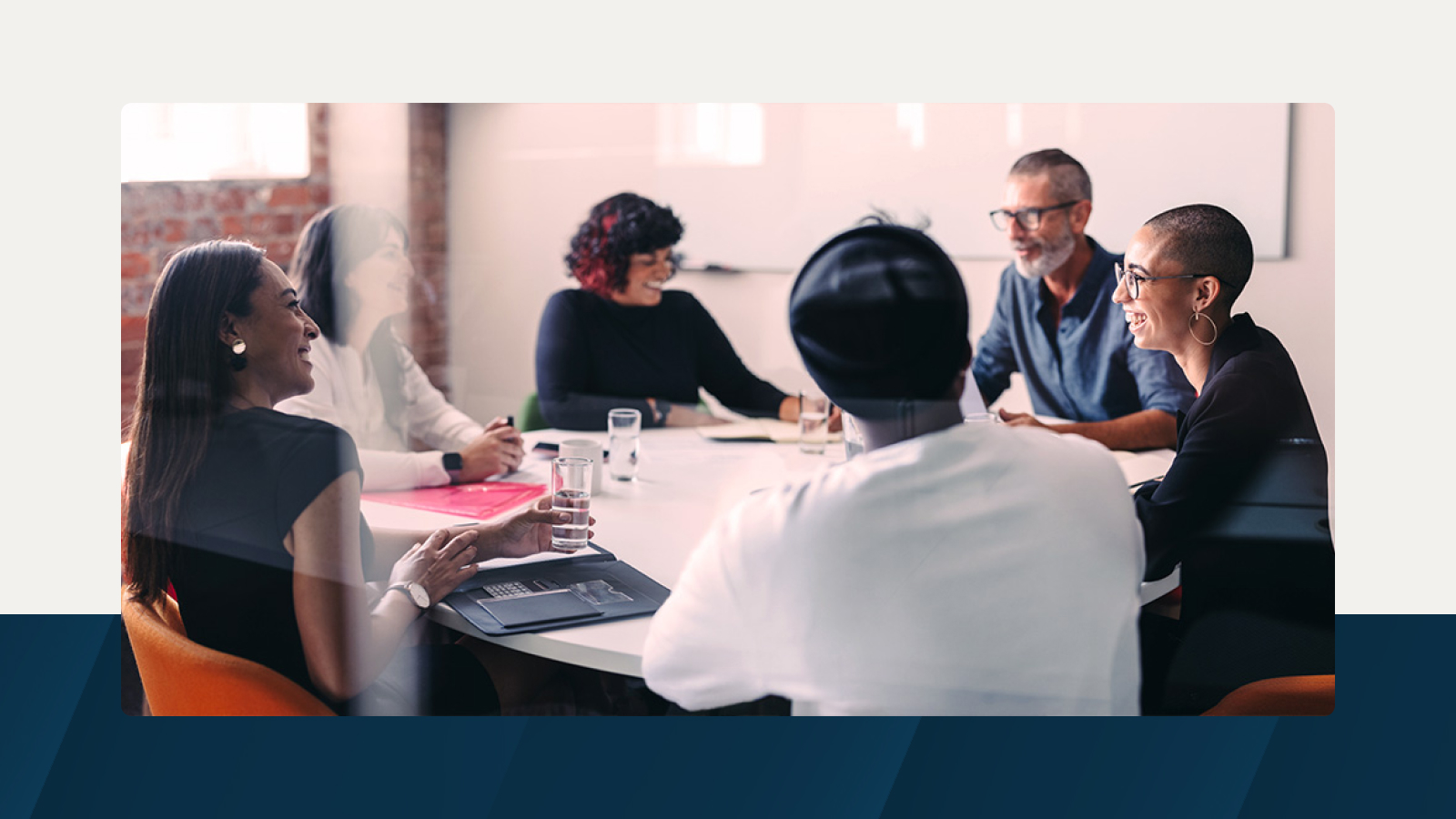 A diverse team engaged in a collaborative discussion in a modern meeting room, with participants smiling and strategizing.