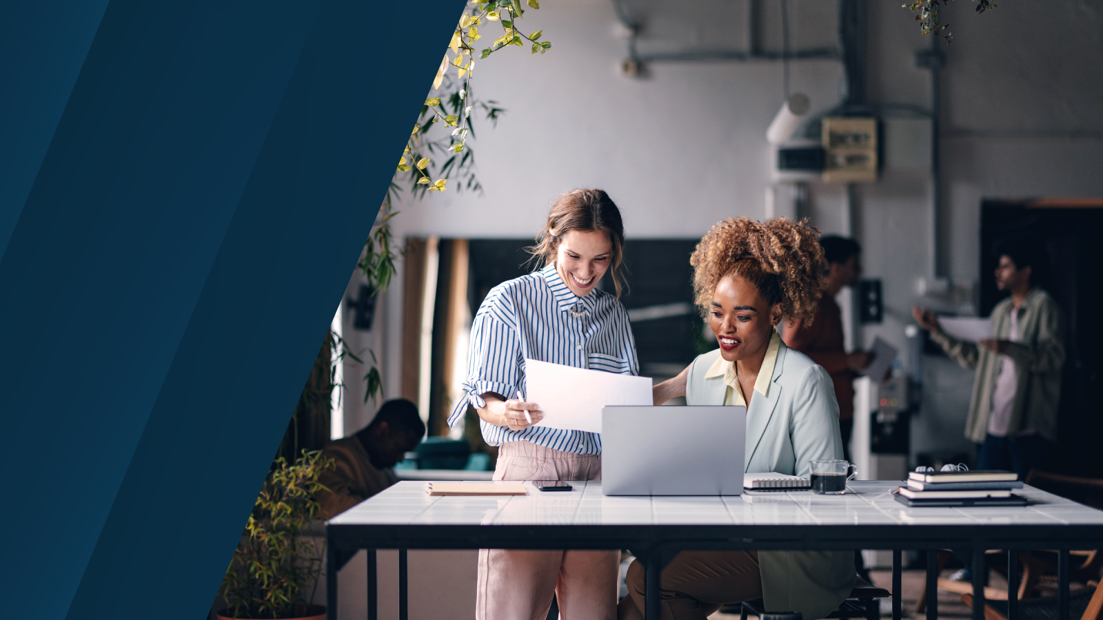Two professionals collaborating in a modern workspace, reviewing financial reports on paper and a laptop