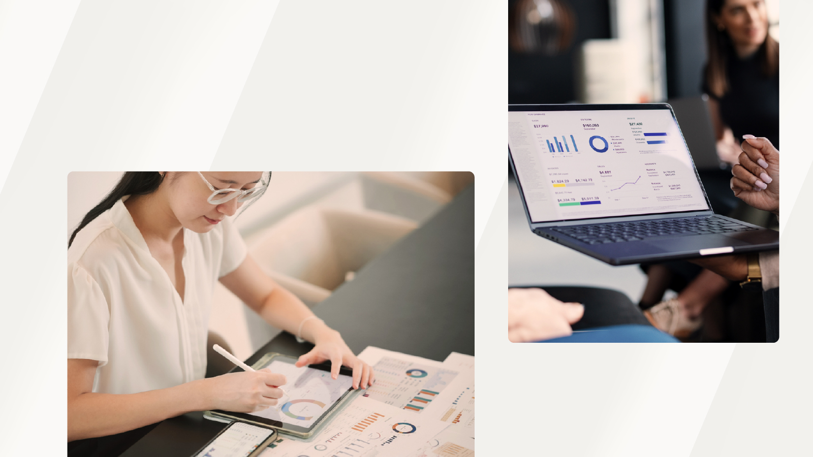 A woman reviewing printed and digital data visualizations on a desk, with another person in the background holding a laptop displaying analytics.