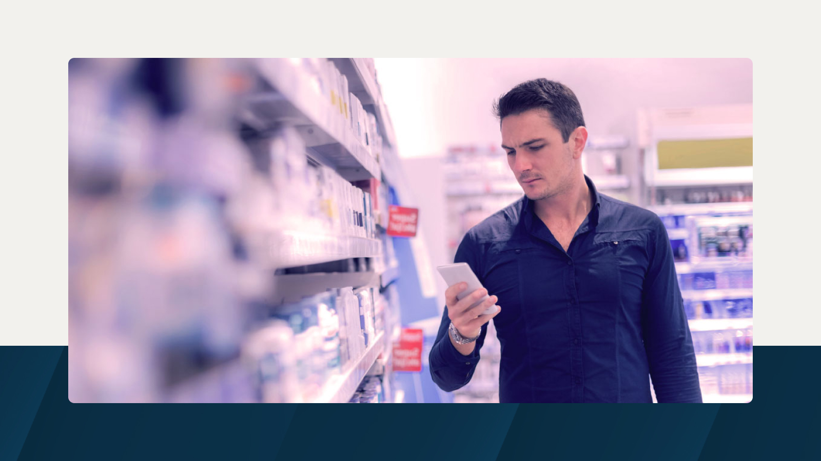 A man in a retail store browsing his phone while shopping, symbolizing data-driven trade promotion planning.