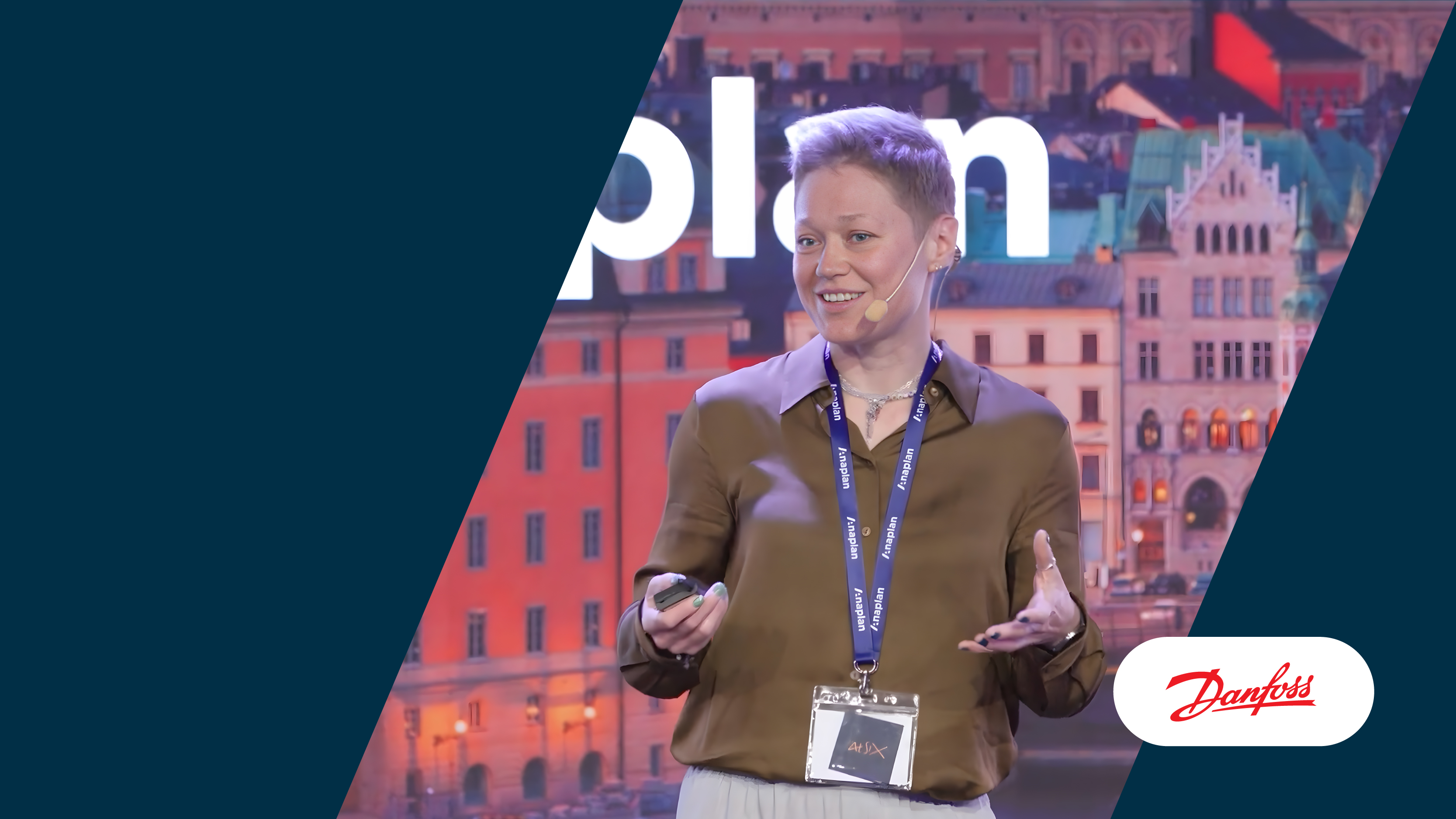 Speaker from Danfoss presenting on stage with Danfoss logo on the lower right