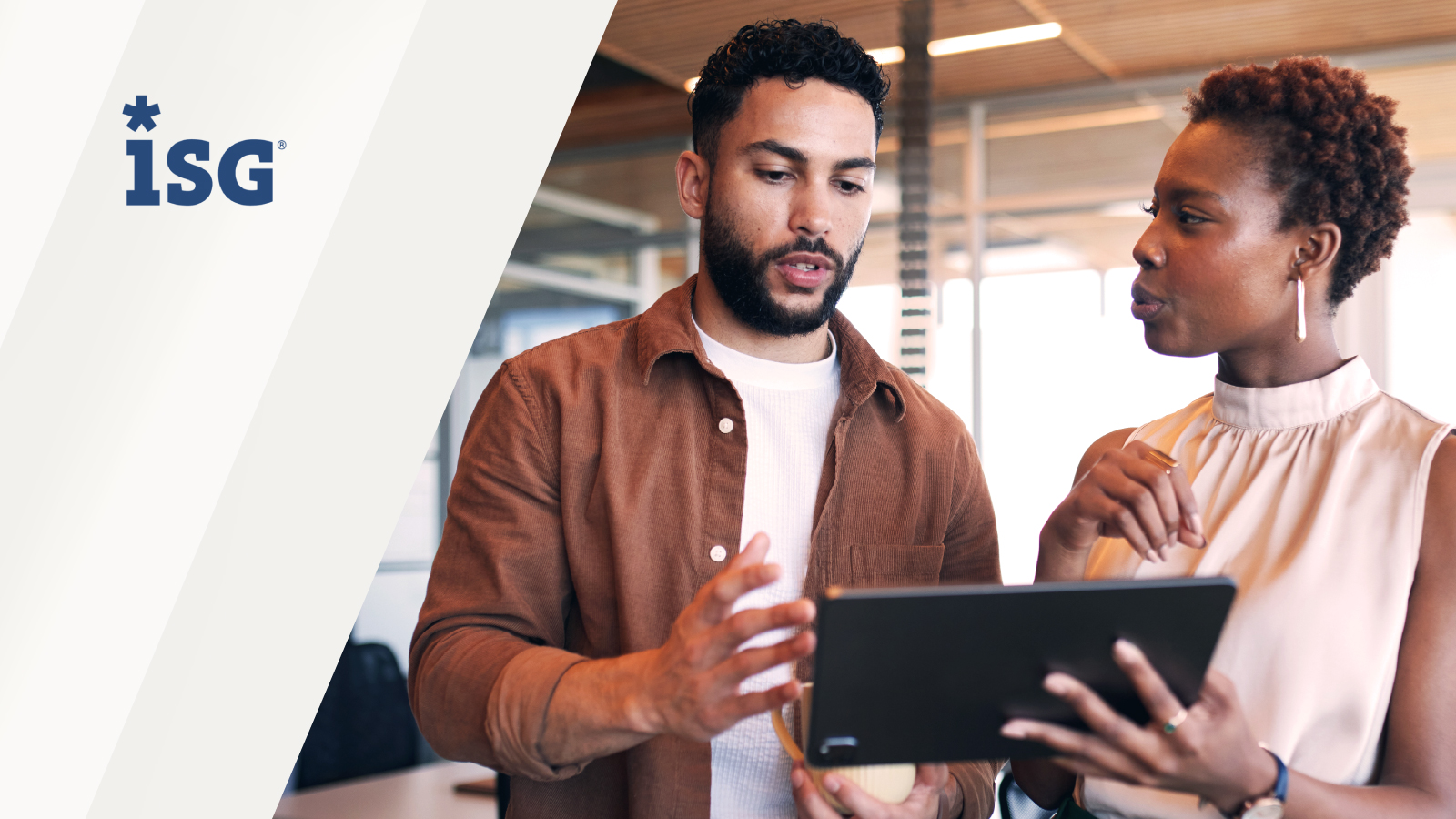 Two professionals in discussion, one holding a tablet, with the ISG logo displayed.